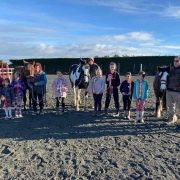 Group of children and adults with horses at Reigning Downs Hauora Centre.