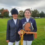 Two women at Reigning Downs Hauora Centre, one holding a horse trophy.