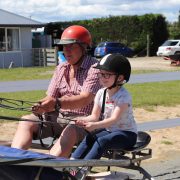Adult and child riding a horse-drawn carriage at Reigning Downs Hauora Centre.